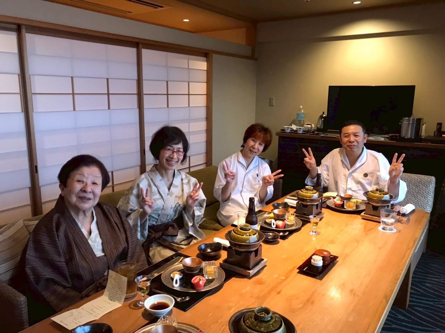 楽しくお食事する高齢者に寄り添う介護スタッフ