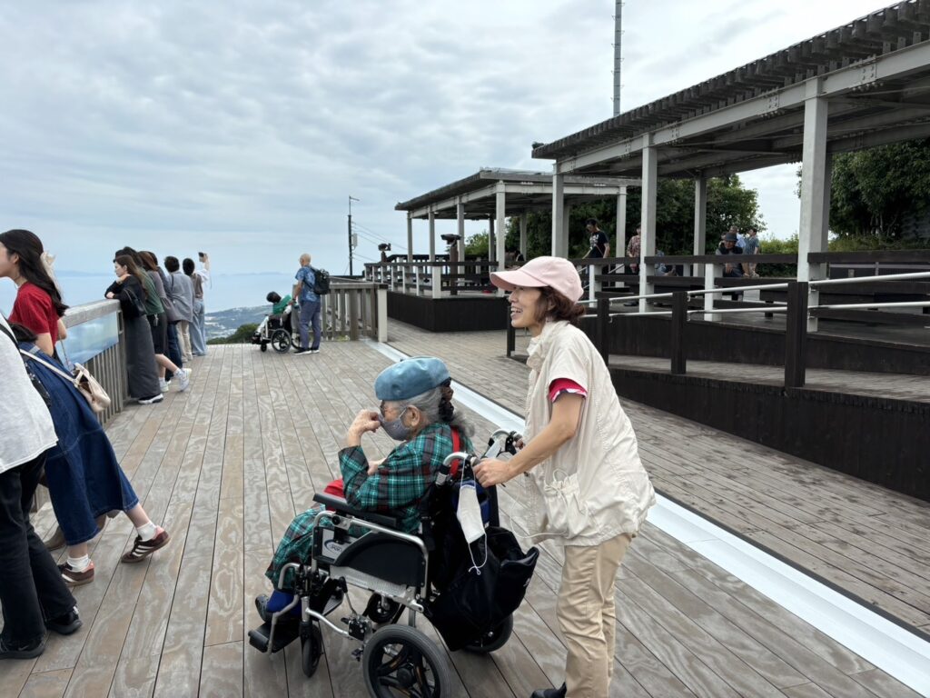 車椅子に乗った高齢者に寄り添う介護スタッフ
