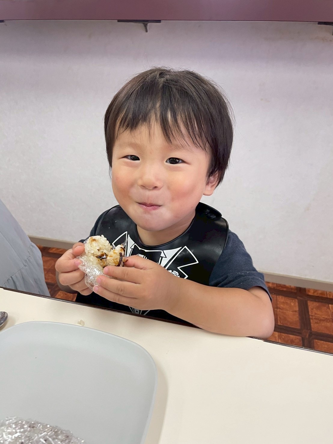 おにぎりを美味しそうに食べる男の子